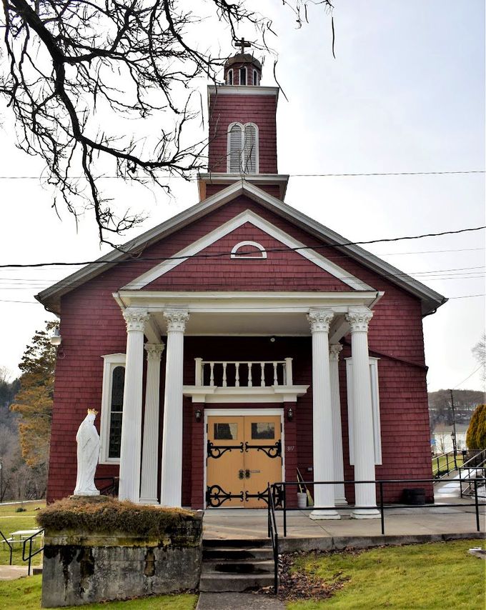 A red church with white columns and a yellow door