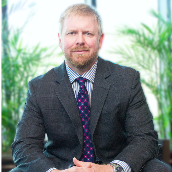 Male personal injury lawyer in a suit and tie is sitting on a couch.