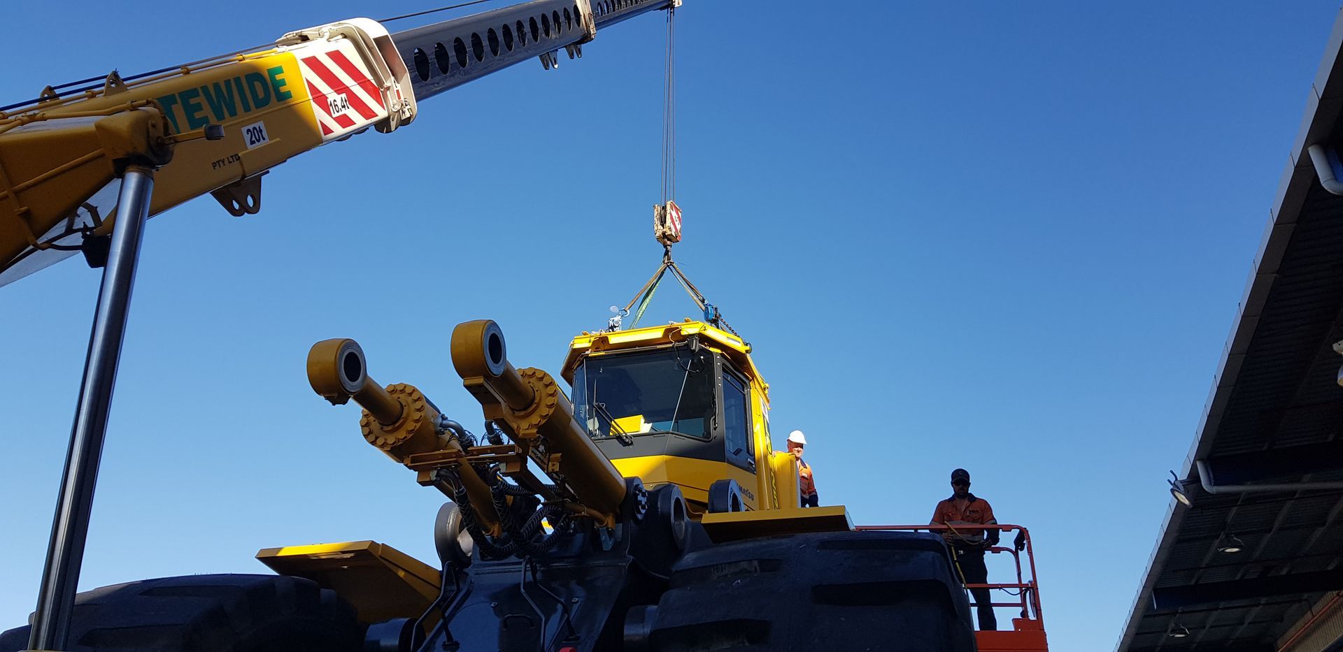 Orange Truck Crane and Two Drilling Rigs Against a Clear Blue Sky — Statewide Lift & Shift Pty Ltd In Bowen, QLD