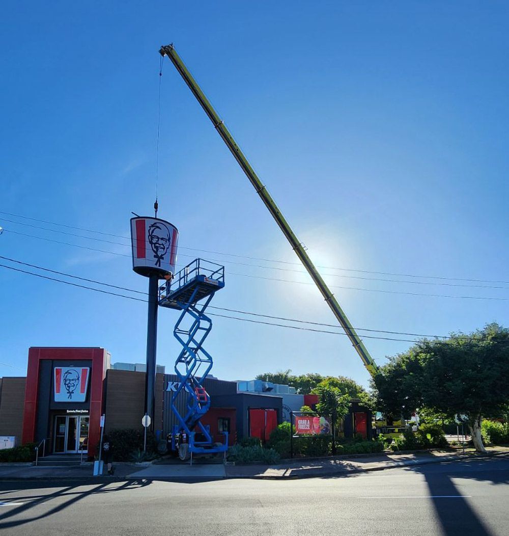 A Kfc Restaurant With a Tall Sign Being Worked on by a Lift — Statewide Lift & Shift Pty Ltd In Paget, QLD