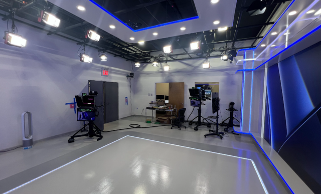 A large studio with a lot of lights and cameras.