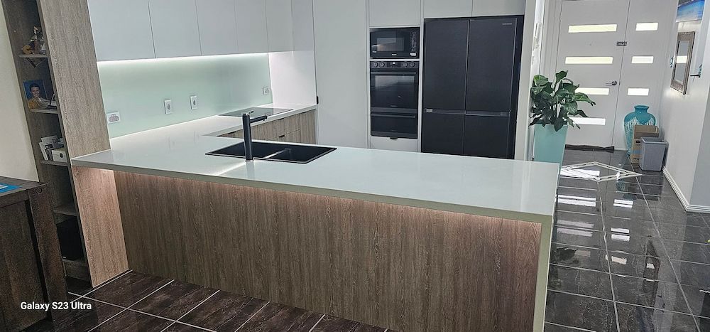 Modern Kitchen With White Countertops, and Stainless Steel Appliances — White Rose Electrical in Coffs Harbour, NSW