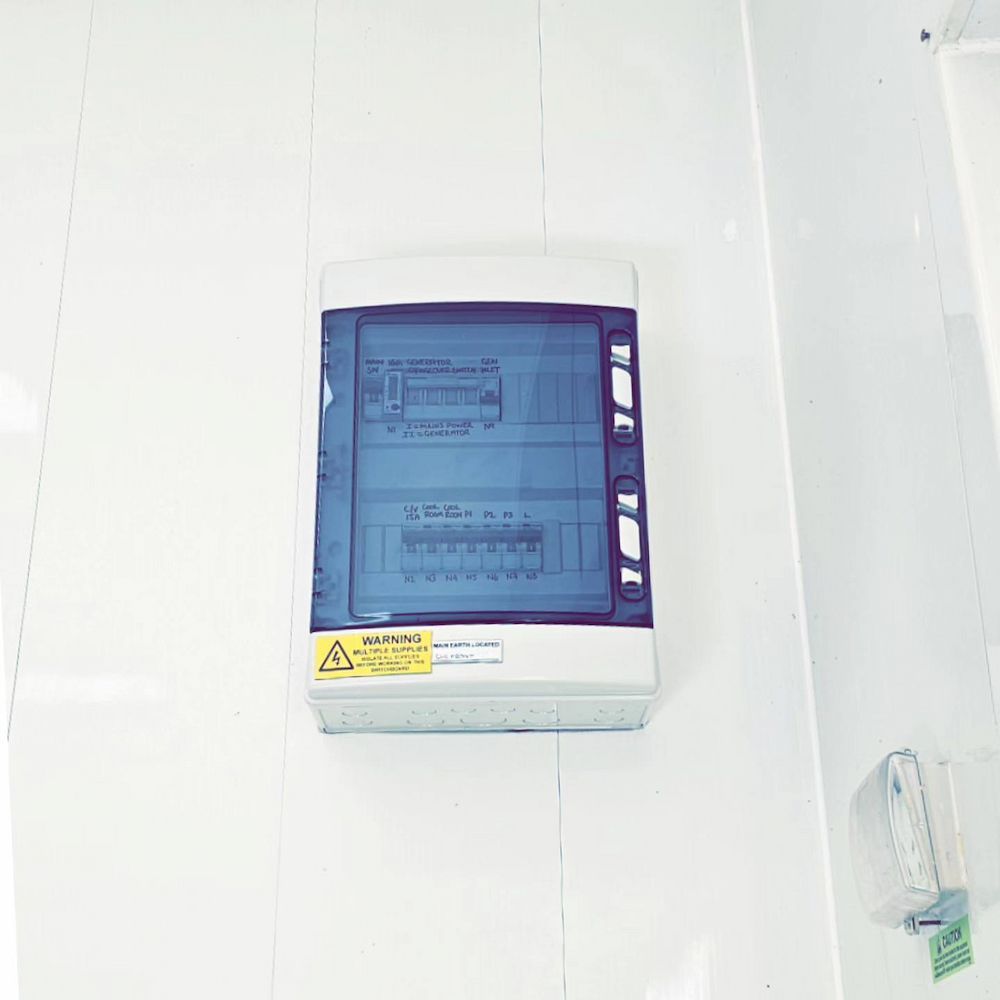 Electrical Fuse Box Mounted on a White Wall With a Transparent Blue Cover — White Rose Electrical in Coffs Harbour, NSW