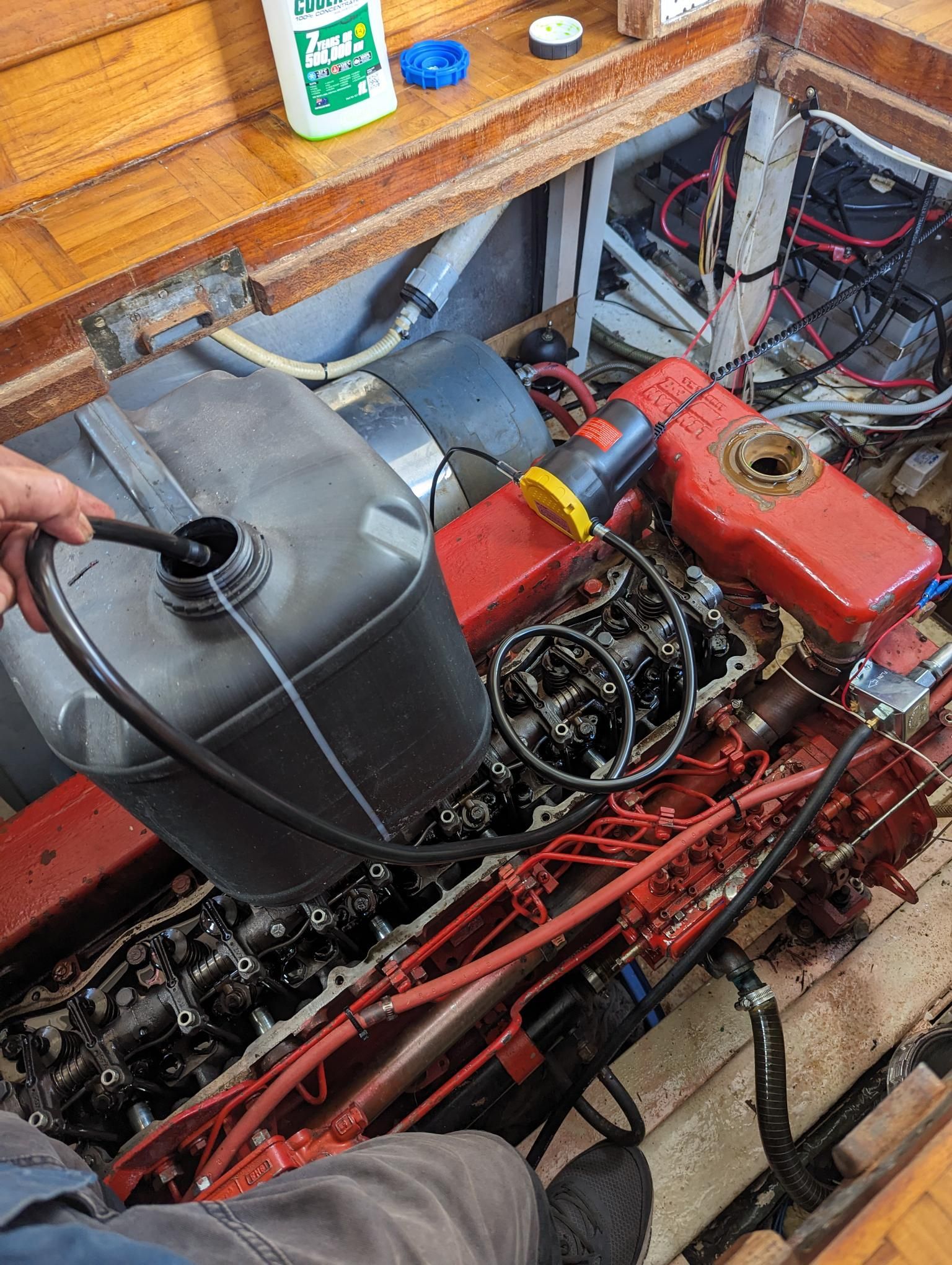 Person Pouring Liquid Into a Boat Engine — Symbiote Systems in Cannonvale, QLD