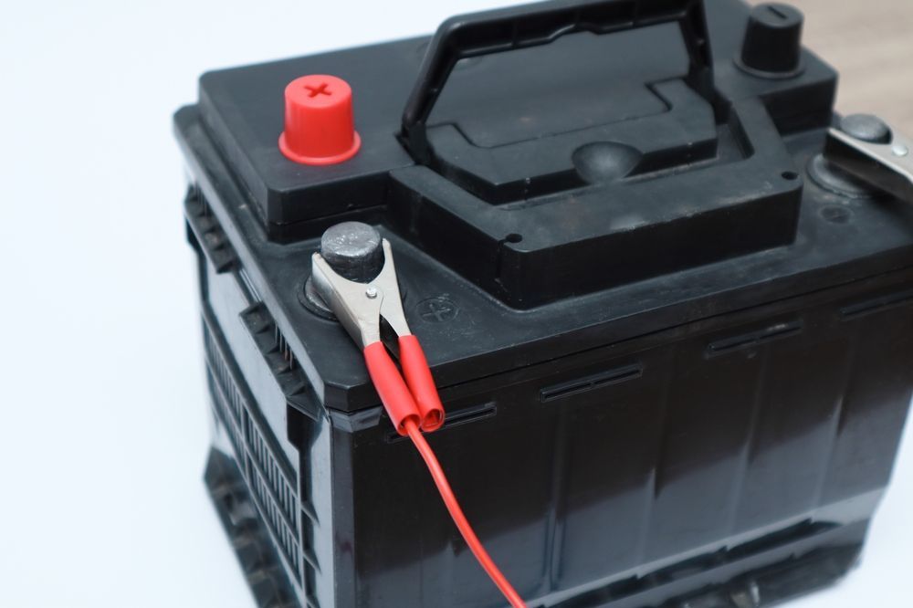 Black Car Battery With Red and Silver Jumper Cable — Symbiote Systems in Cannonvale, QLD