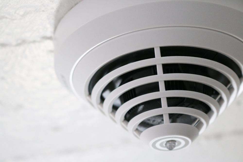 White Smoke Detector Mounted on a White Ceiling — Symbiote Systems in Cannonvale, QLD