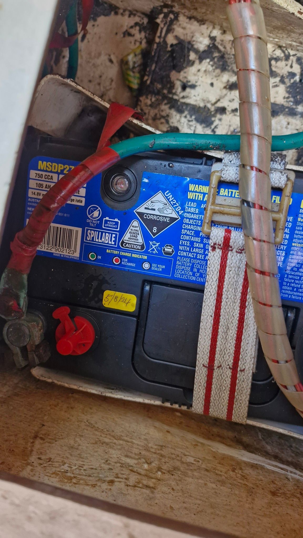 Car Battery With Red and Green Cables, Secured by a White Strap With Red Stripes — Symbiote Systems in Airlie Beach, QLD