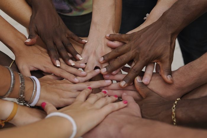 people of different races putting their hands together