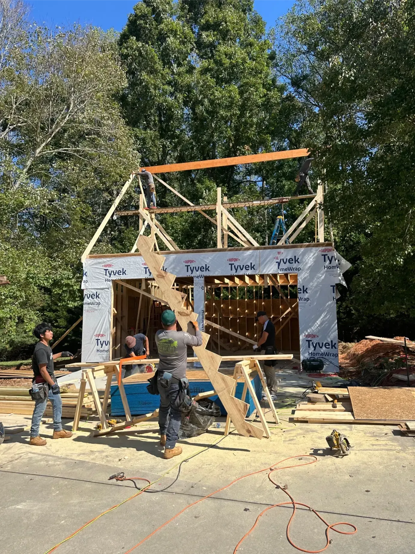Person using a power drill to screw composite decking boards to a metal frame. Outdoors.