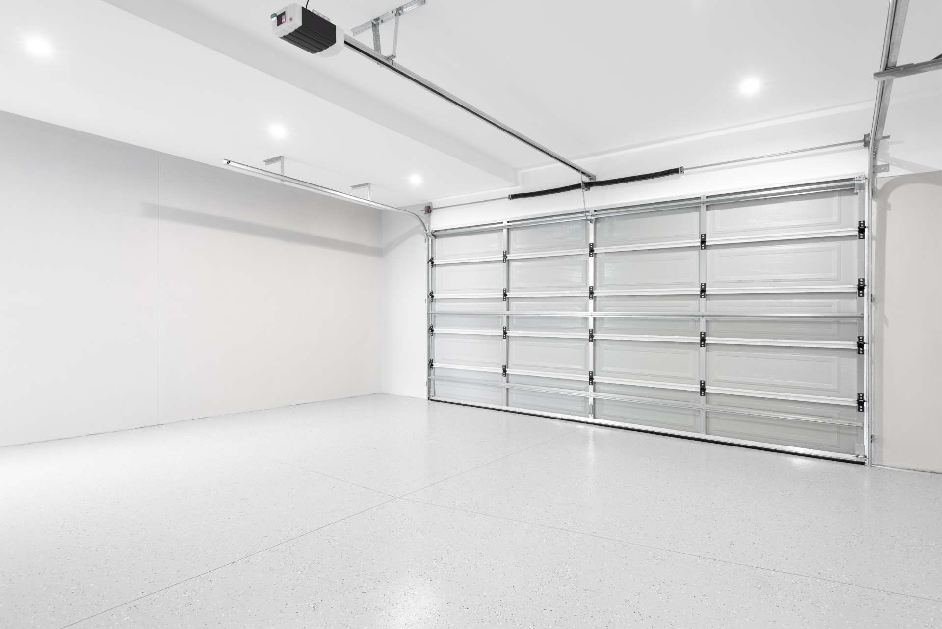 Empty, modern garage with white walls and a clear glass door.