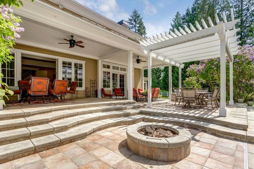 Patio with stone steps, fire pit, covered porch, pergola, and outdoor seating.