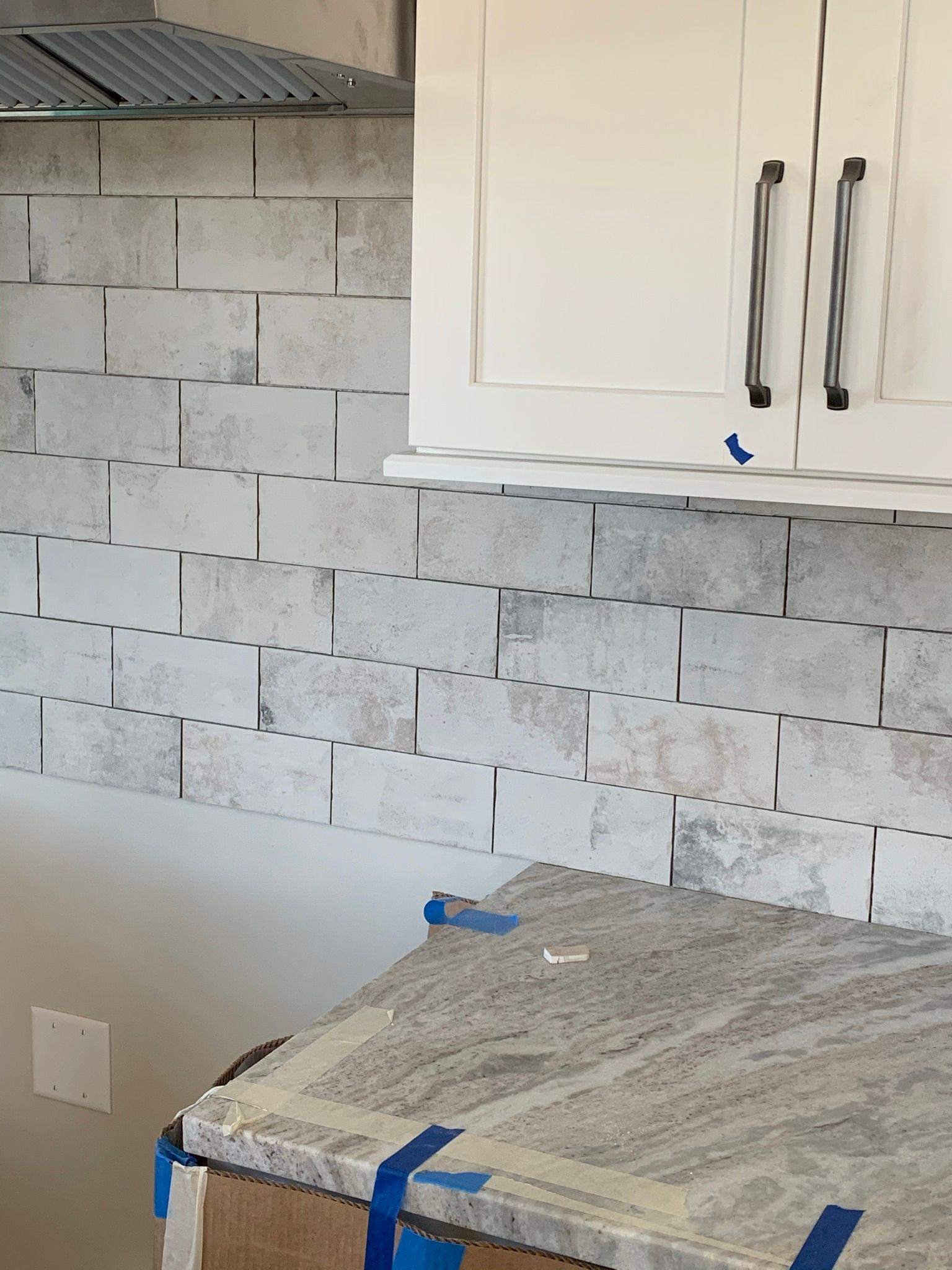 A kitchen with white cabinets and a granite counter top