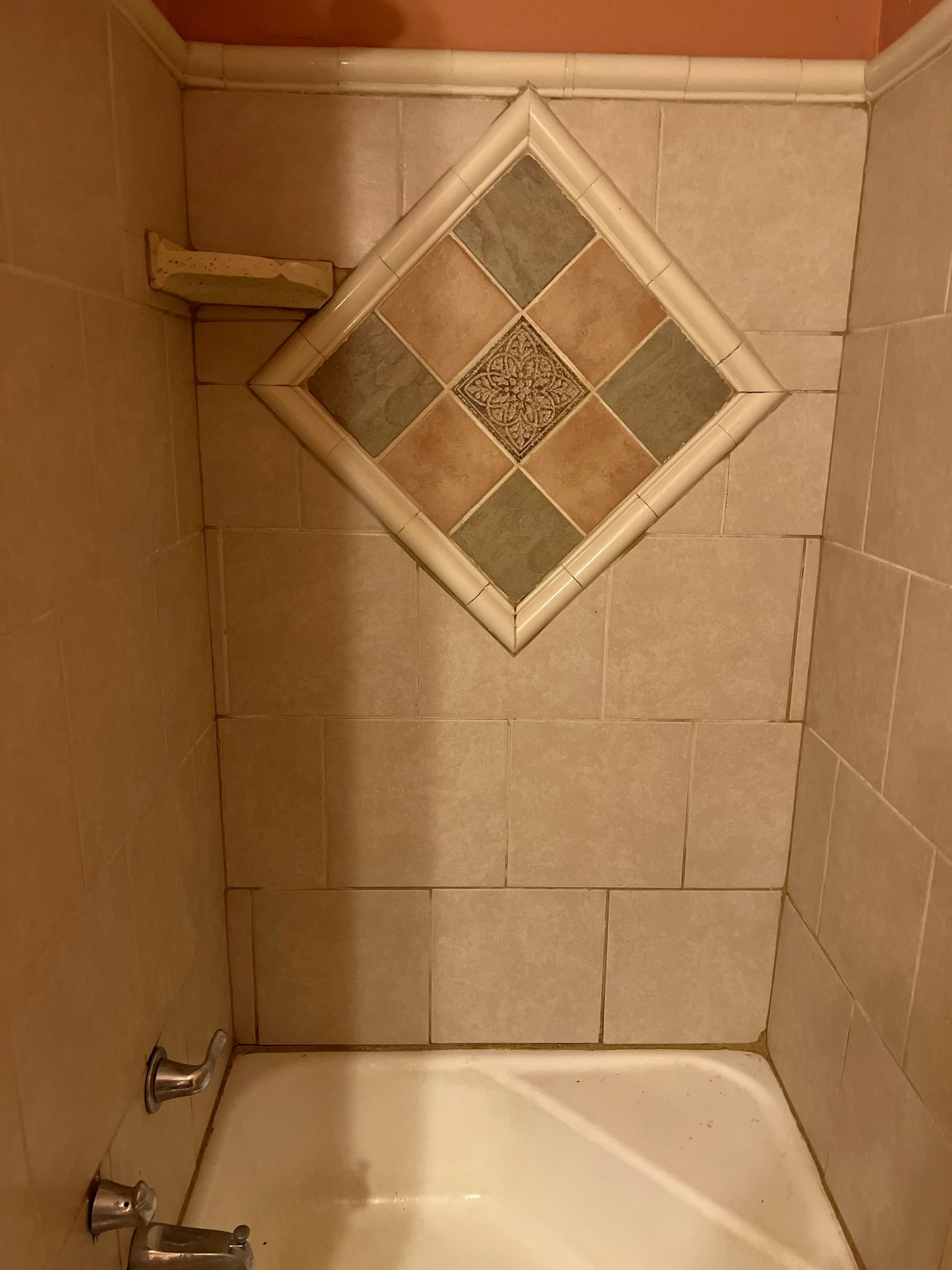 A bathroom with a tiled wall and a bathtub