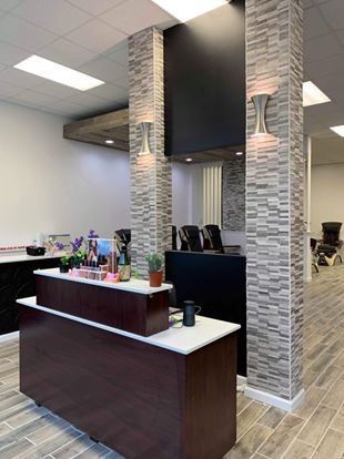 A reception desk in a salon with a brick wall behind it.