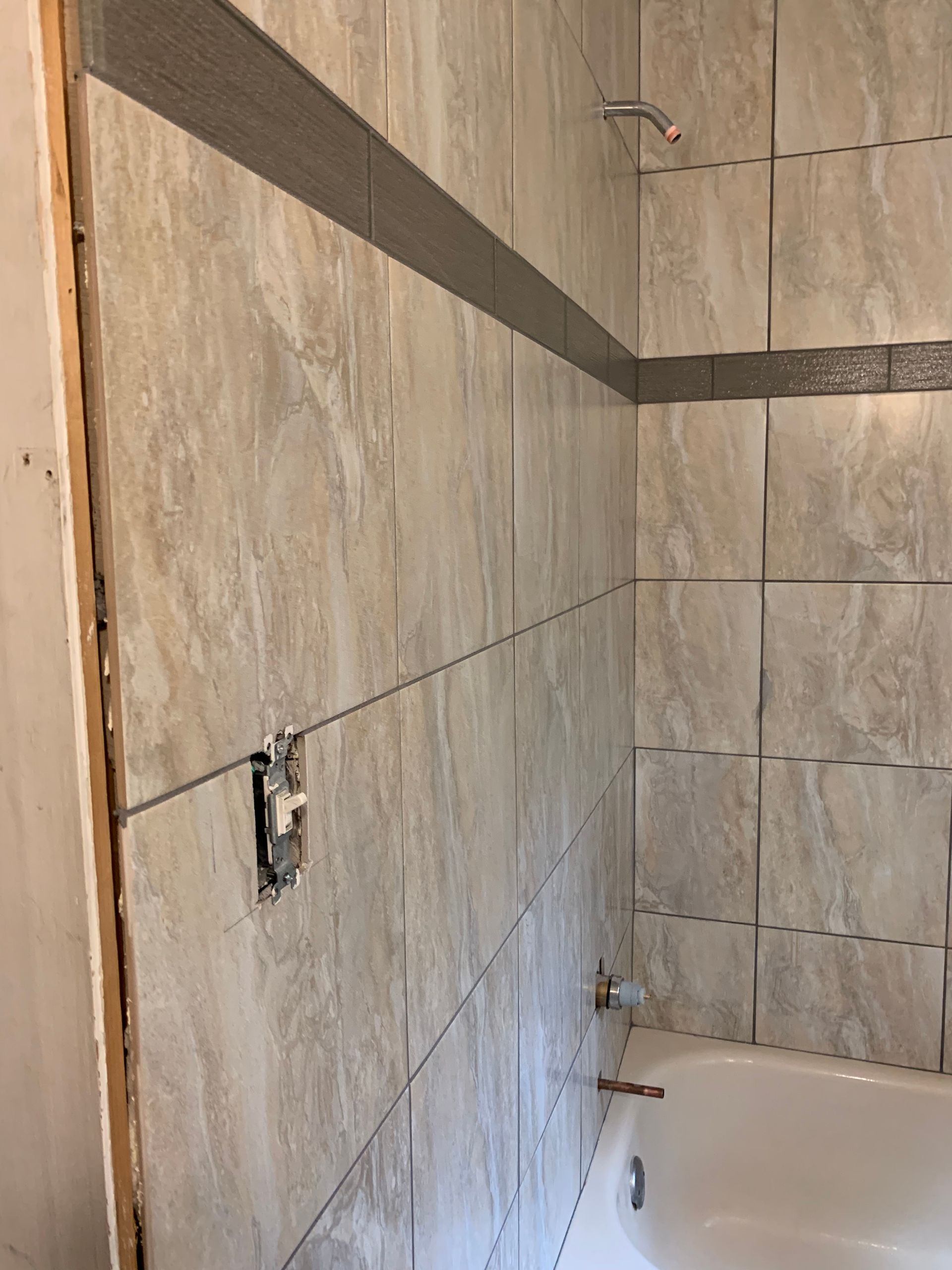 A bathroom with tiled walls and a bathtub