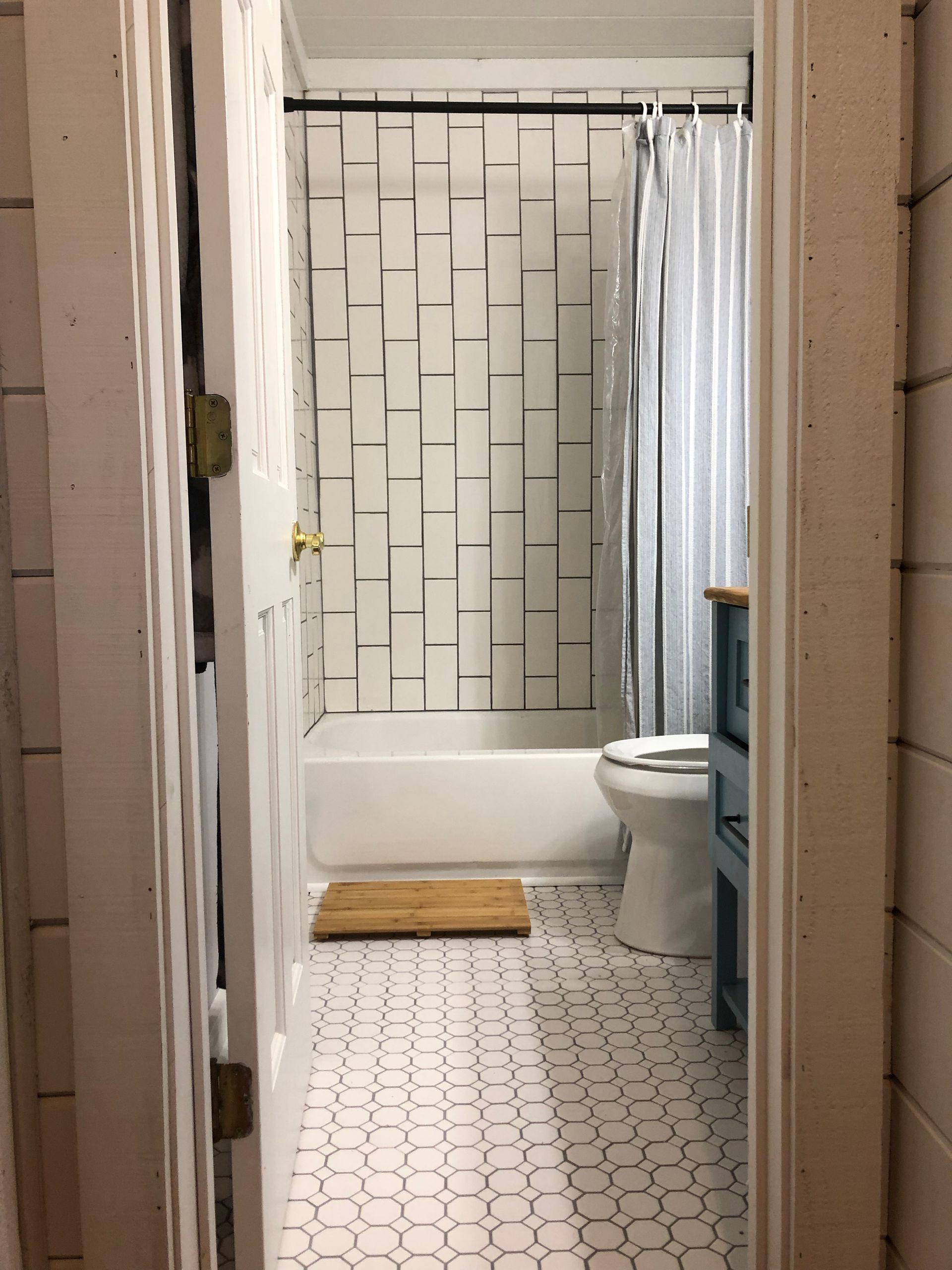 A bathroom with a bathtub toilet and shower curtain