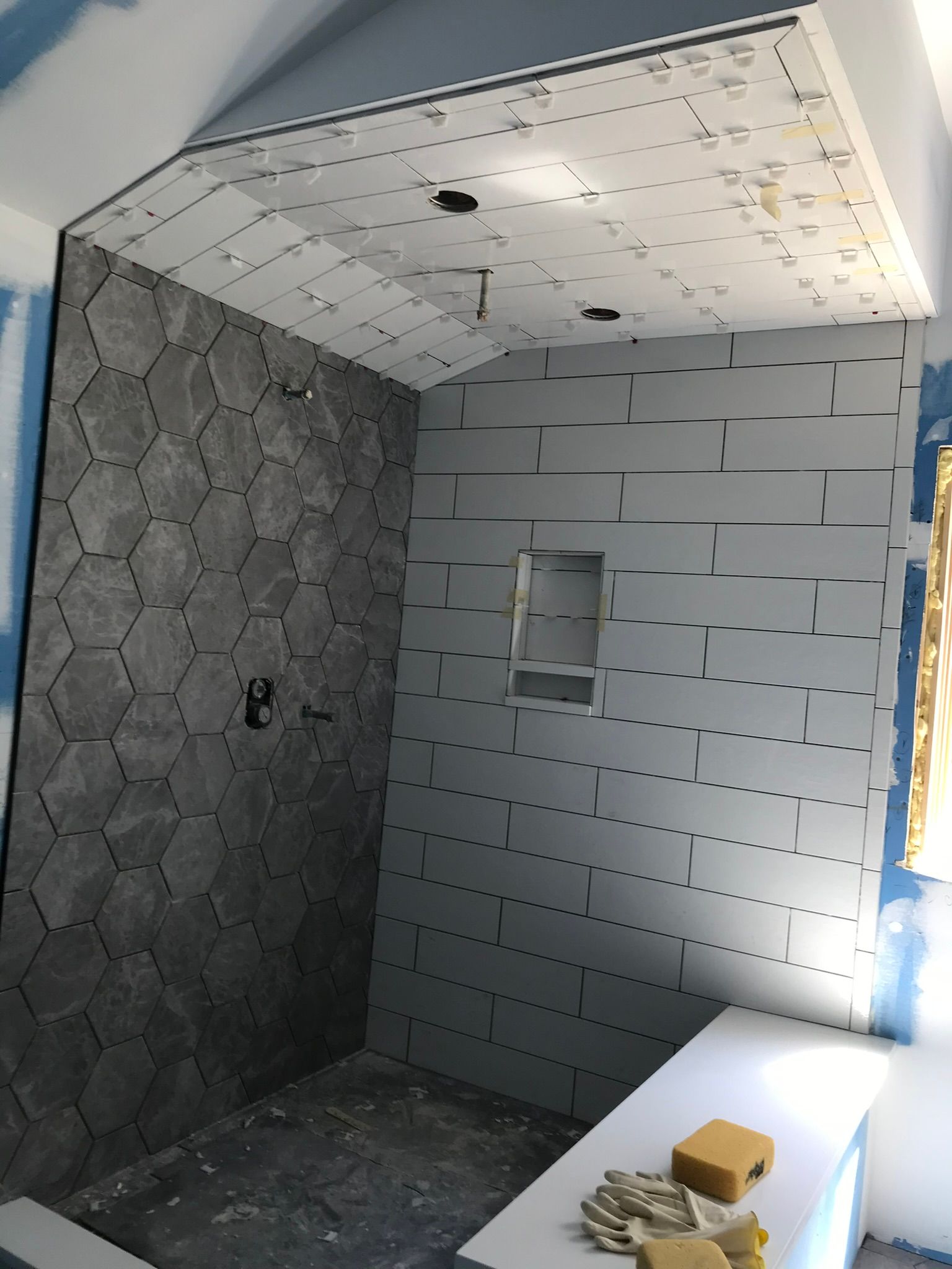 A bathroom under construction with a shower and a window