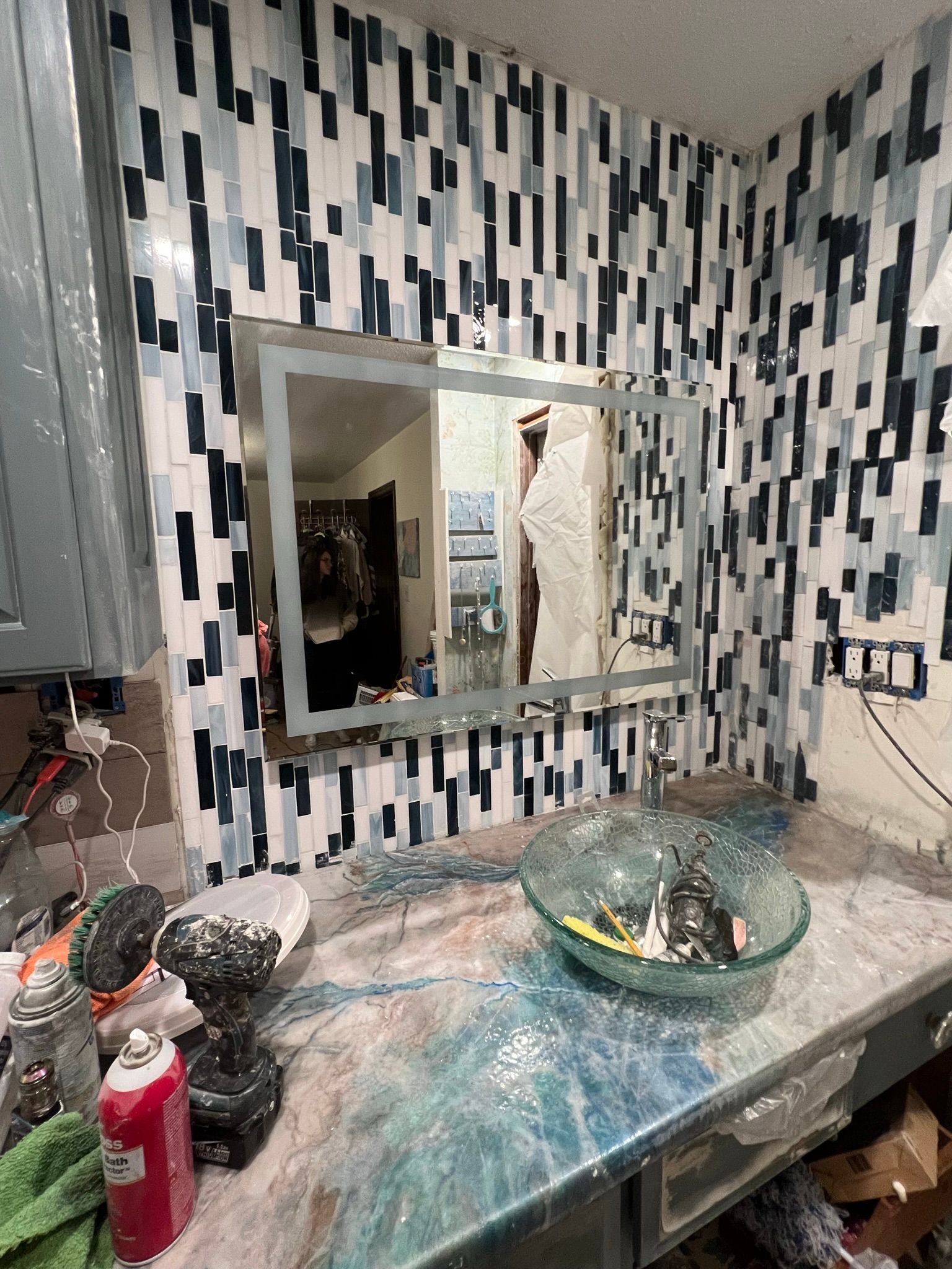 A bathroom with a large mirror and a sink