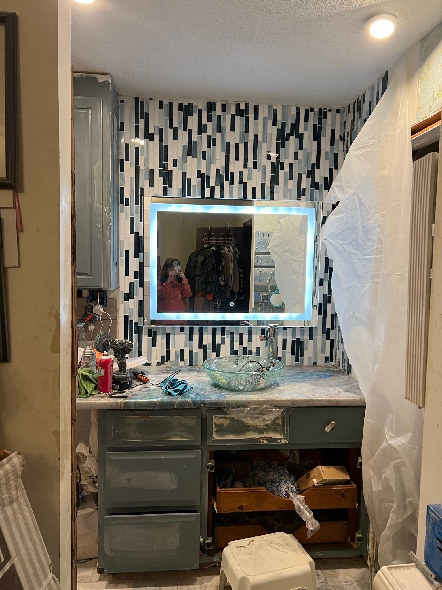 A bathroom with a vanity and a large mirror