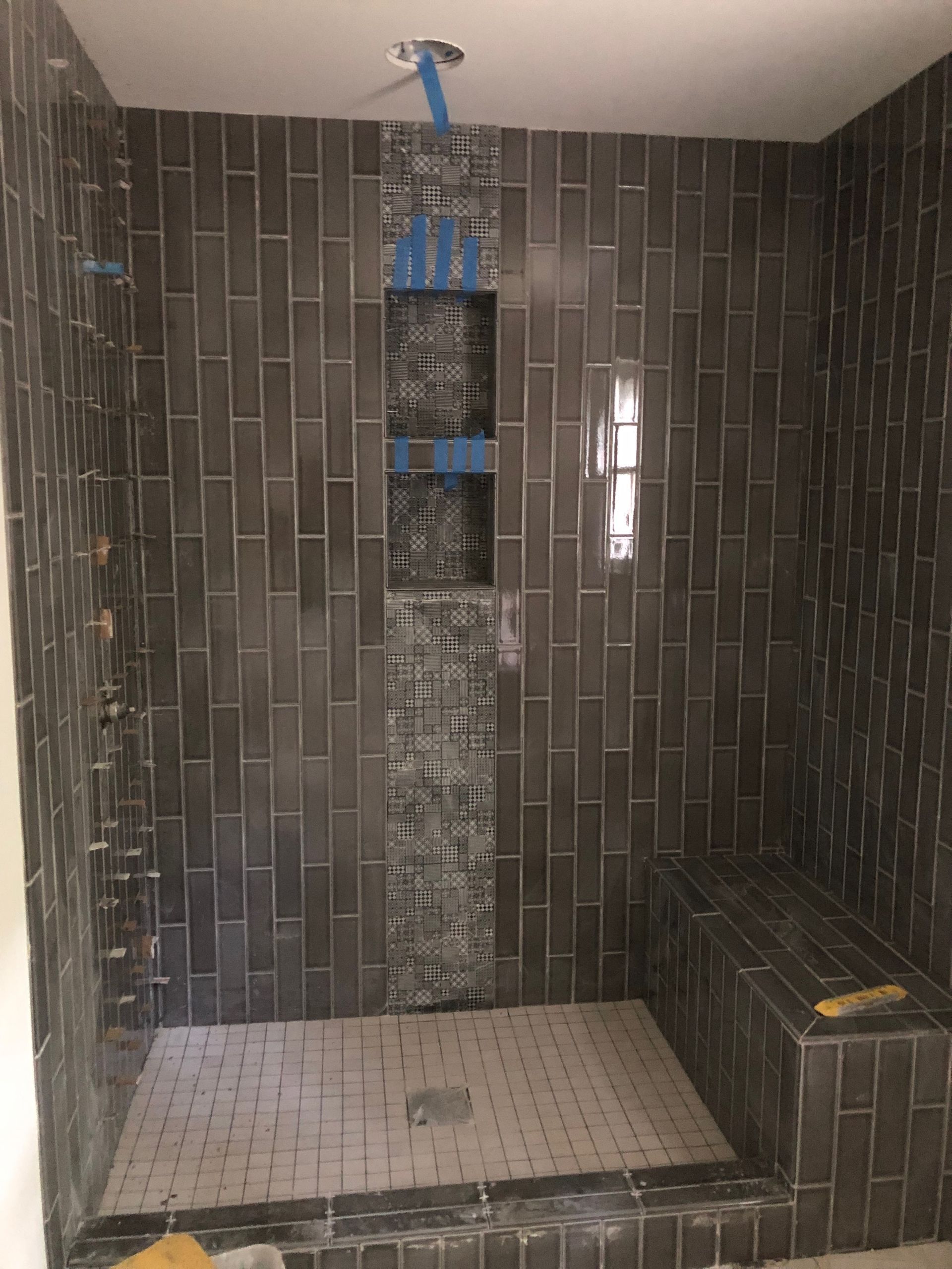 A shower with a blue tape hanging from the ceiling