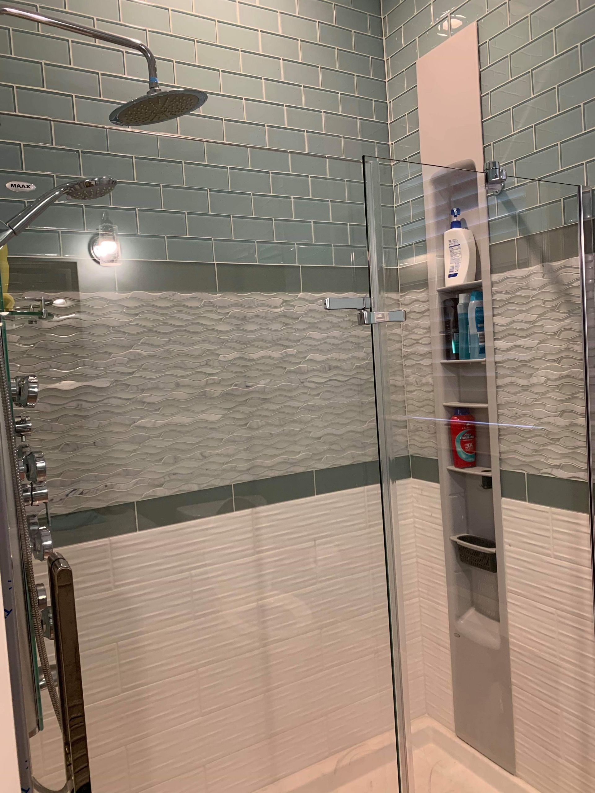 A shower with a glass door and a shower head