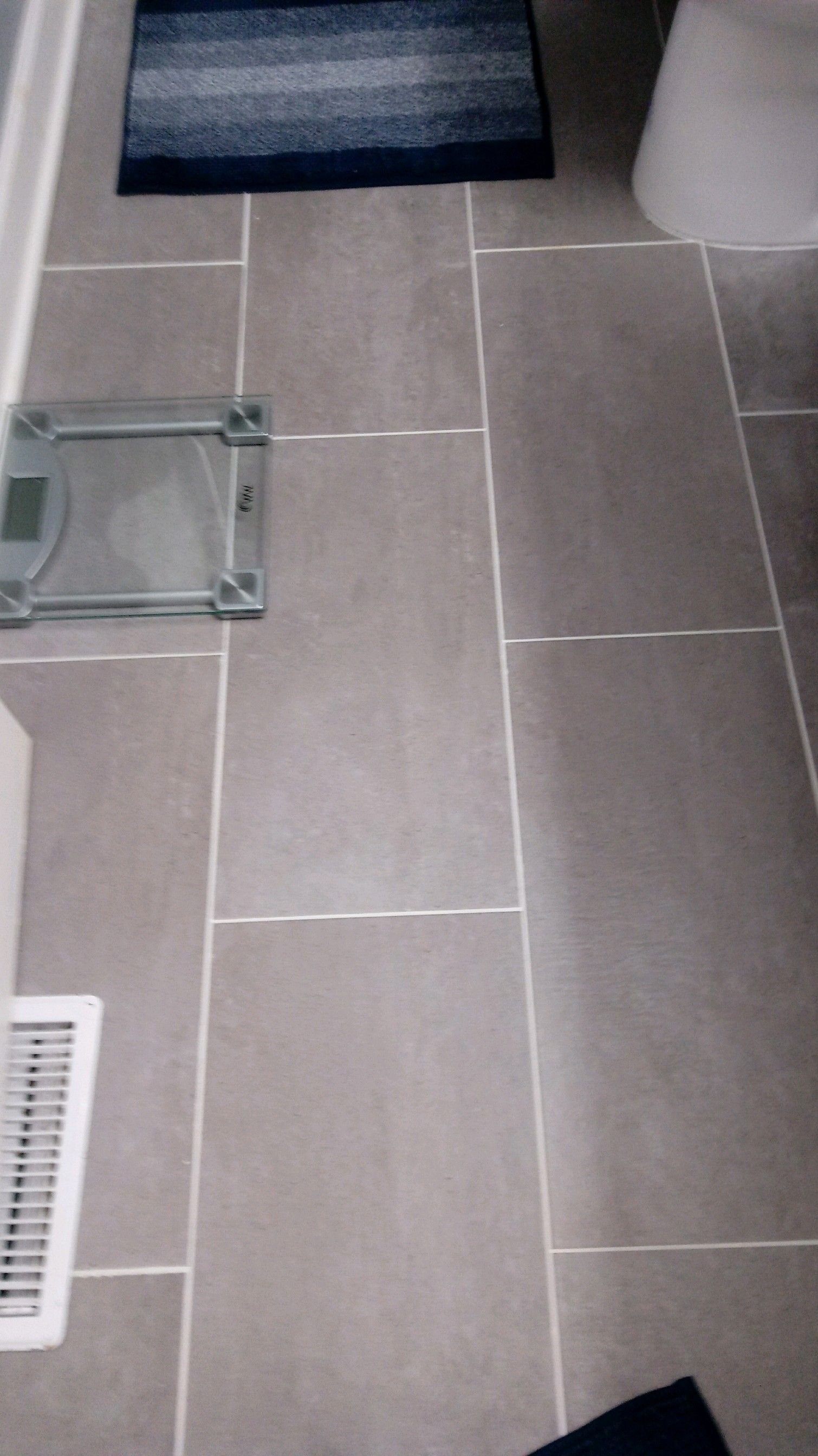 A bathroom with a scale and a rug on the floor