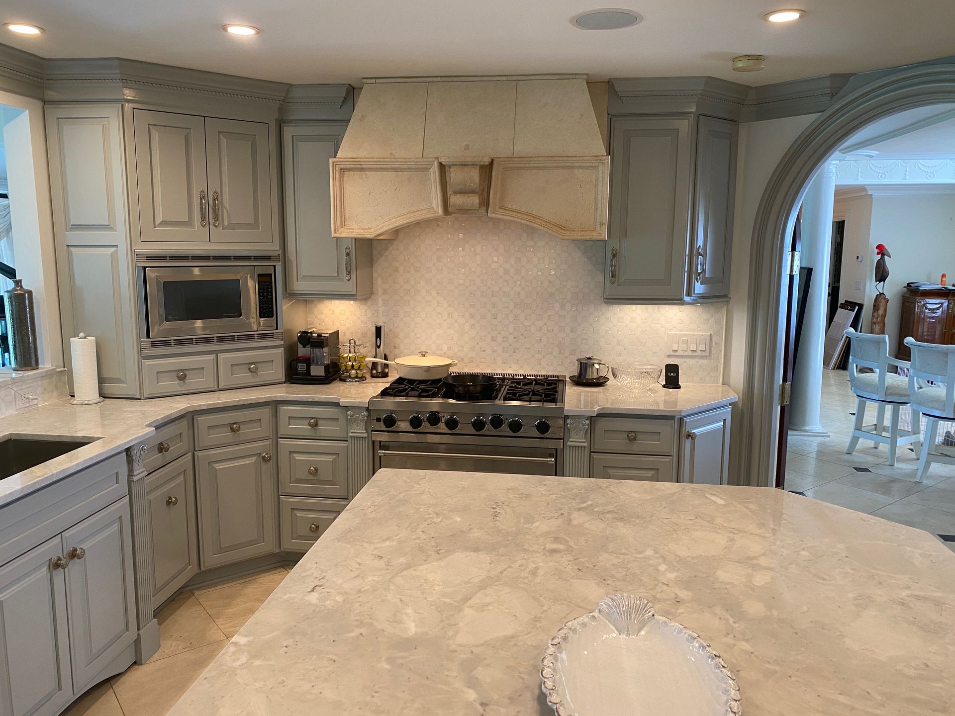 A kitchen with white cabinets and a stove top oven