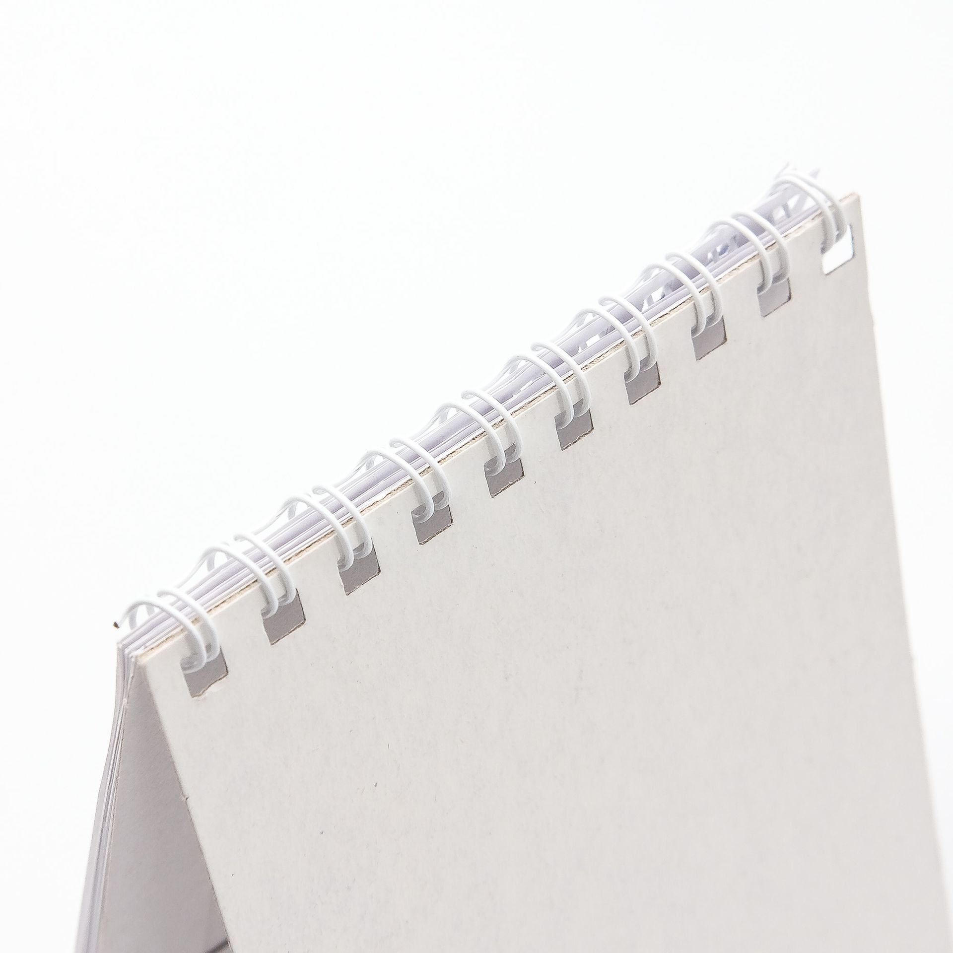 Un primer plano de un cuaderno encuadernado en espiral sobre un fondo blanco.