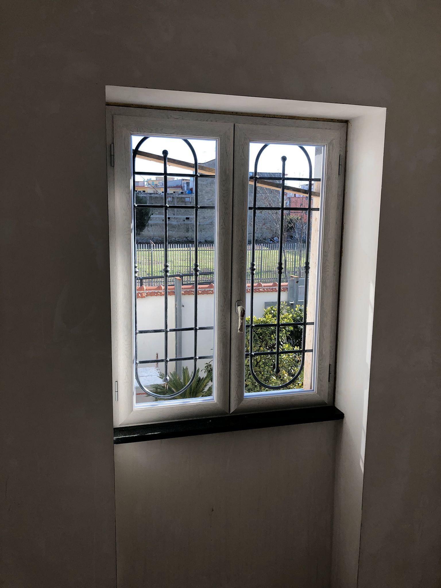 finestra con infissi in alluminio e grata di protezione