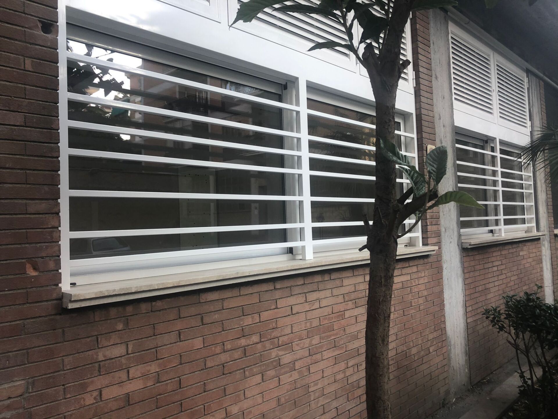 finestre con grate di protezione in ferro verniciate bianche