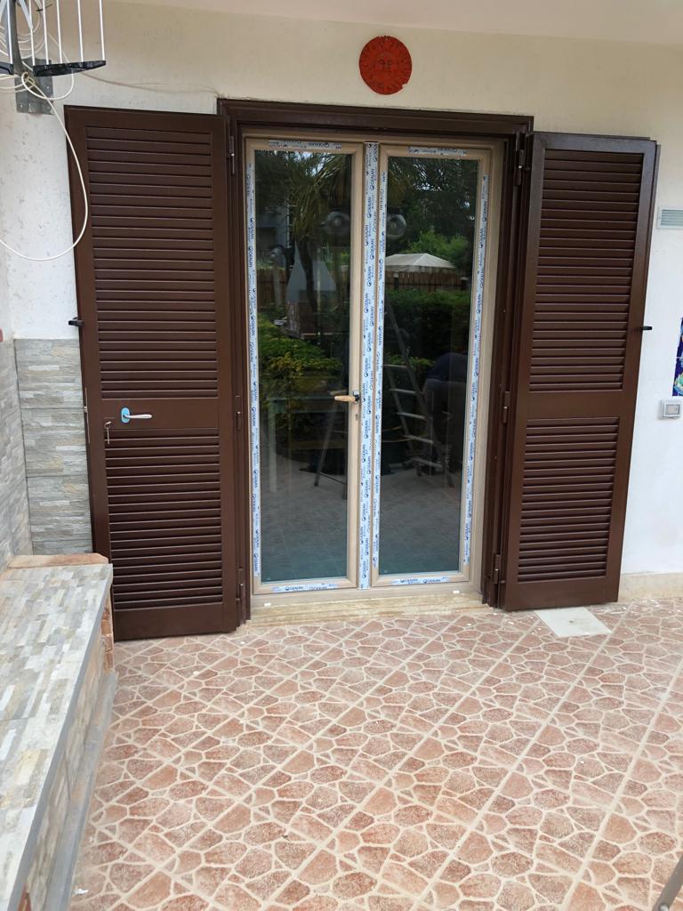 balcone con infissi in PVC e persiane
