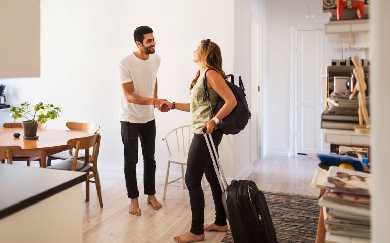 man and woman shaking hands in living room