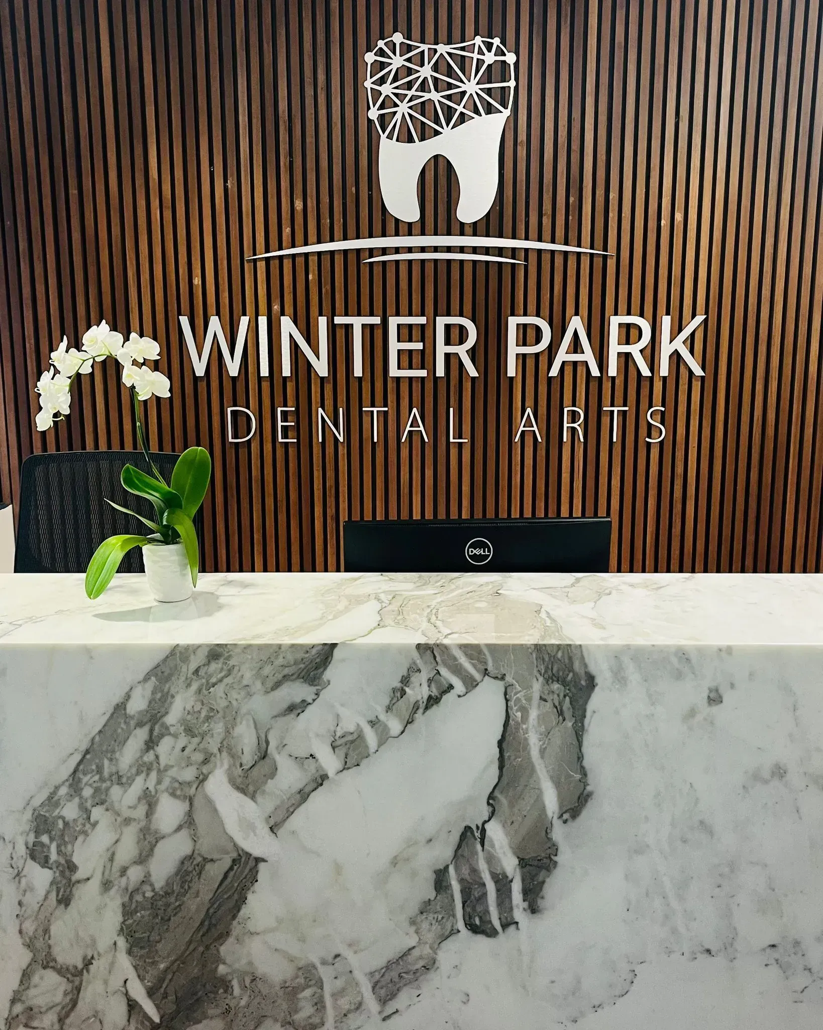 A dental office with a marble counter top and a wooden wall.