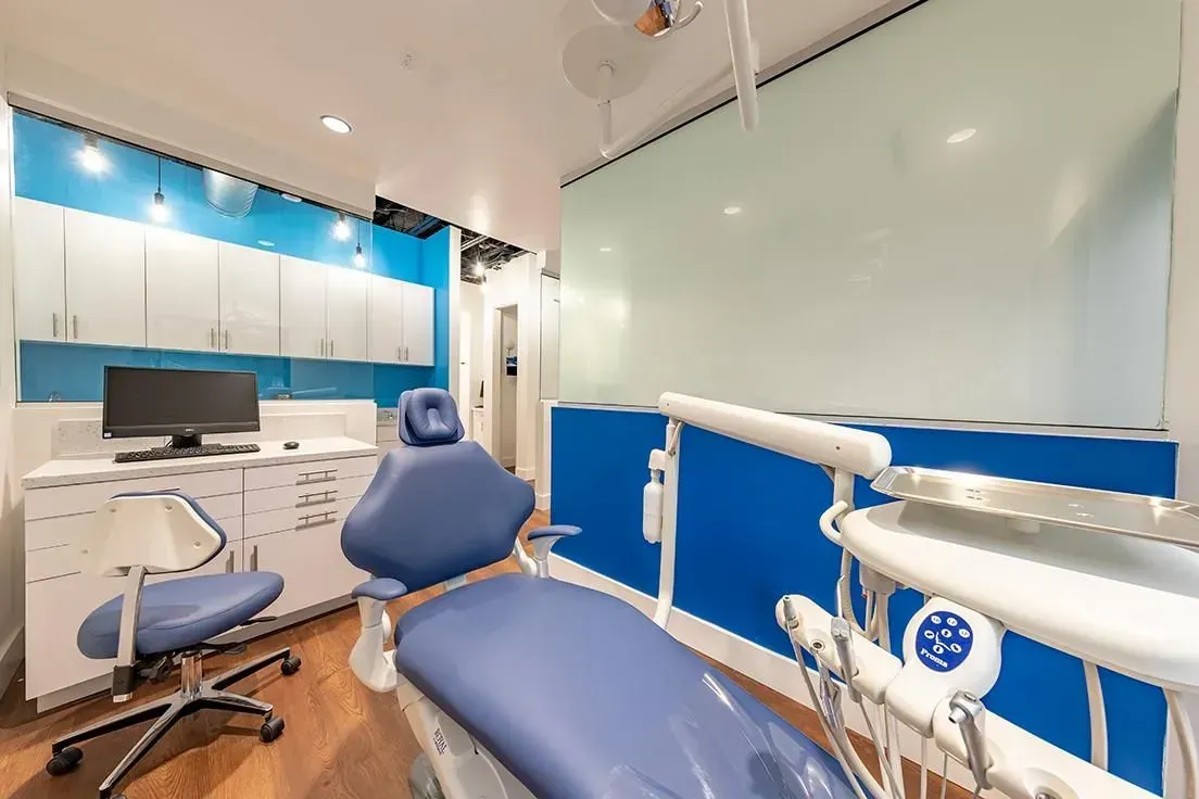 A dental office with a dental chair and a computer.