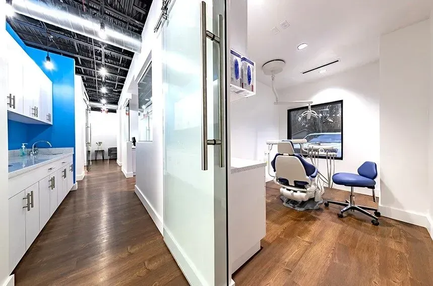 A dental office with a dental chair and a sink.