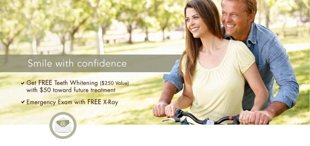 A man and woman are smiling while riding a bike in a park.