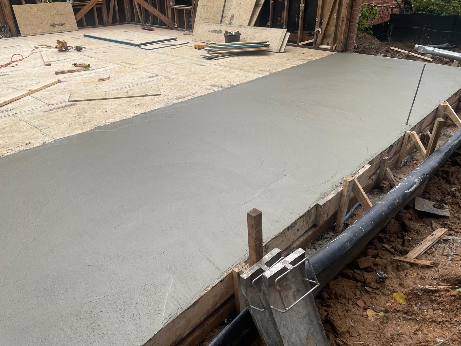 A concrete walkway is being built on a construction site.