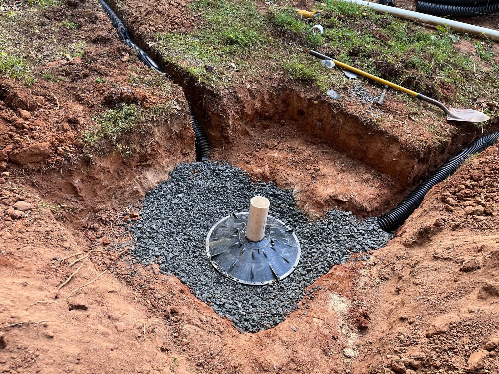 A drainage system is being installed in a hole in the ground.