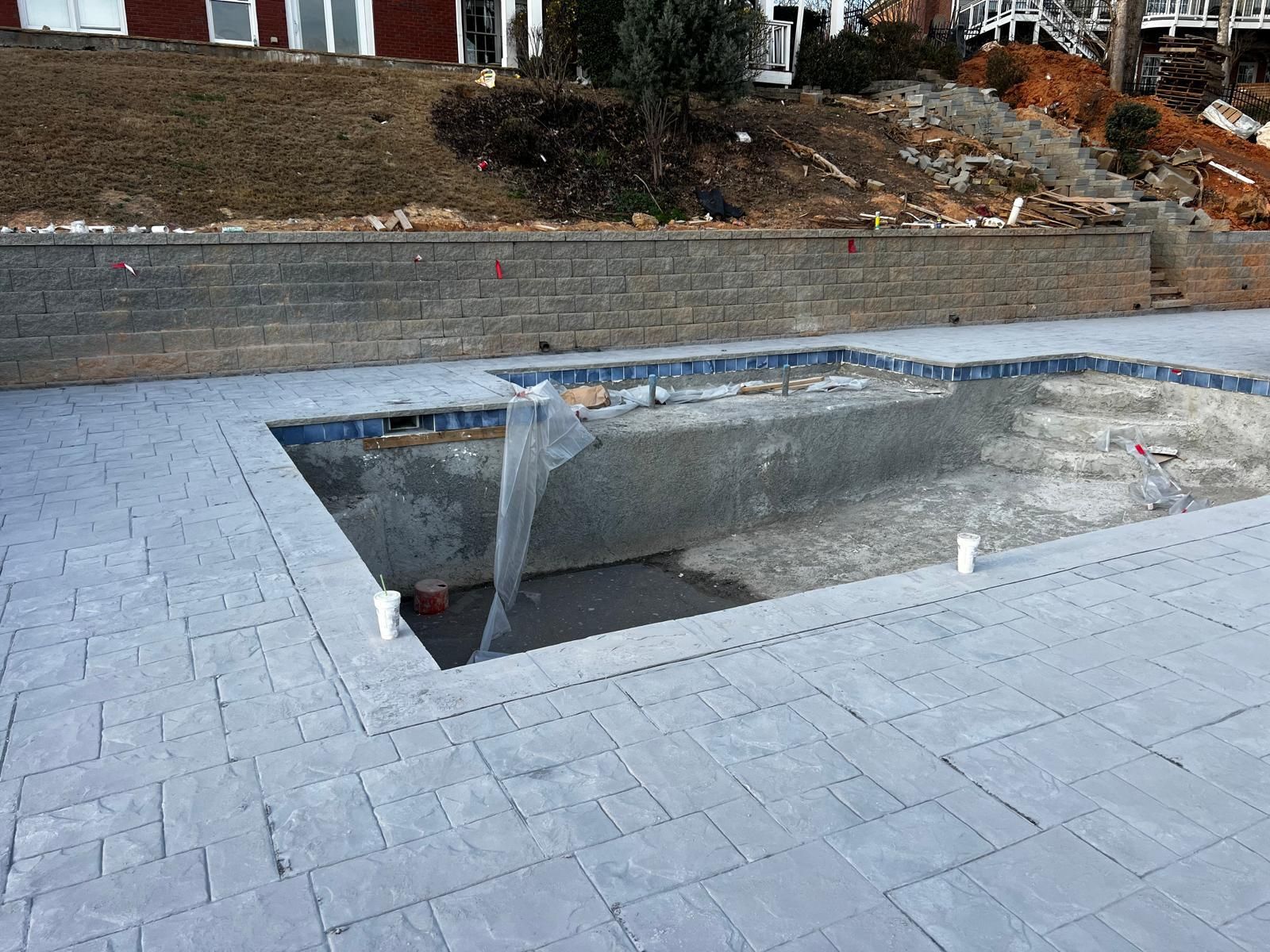 A swimming pool is being built in the backyard of a house.