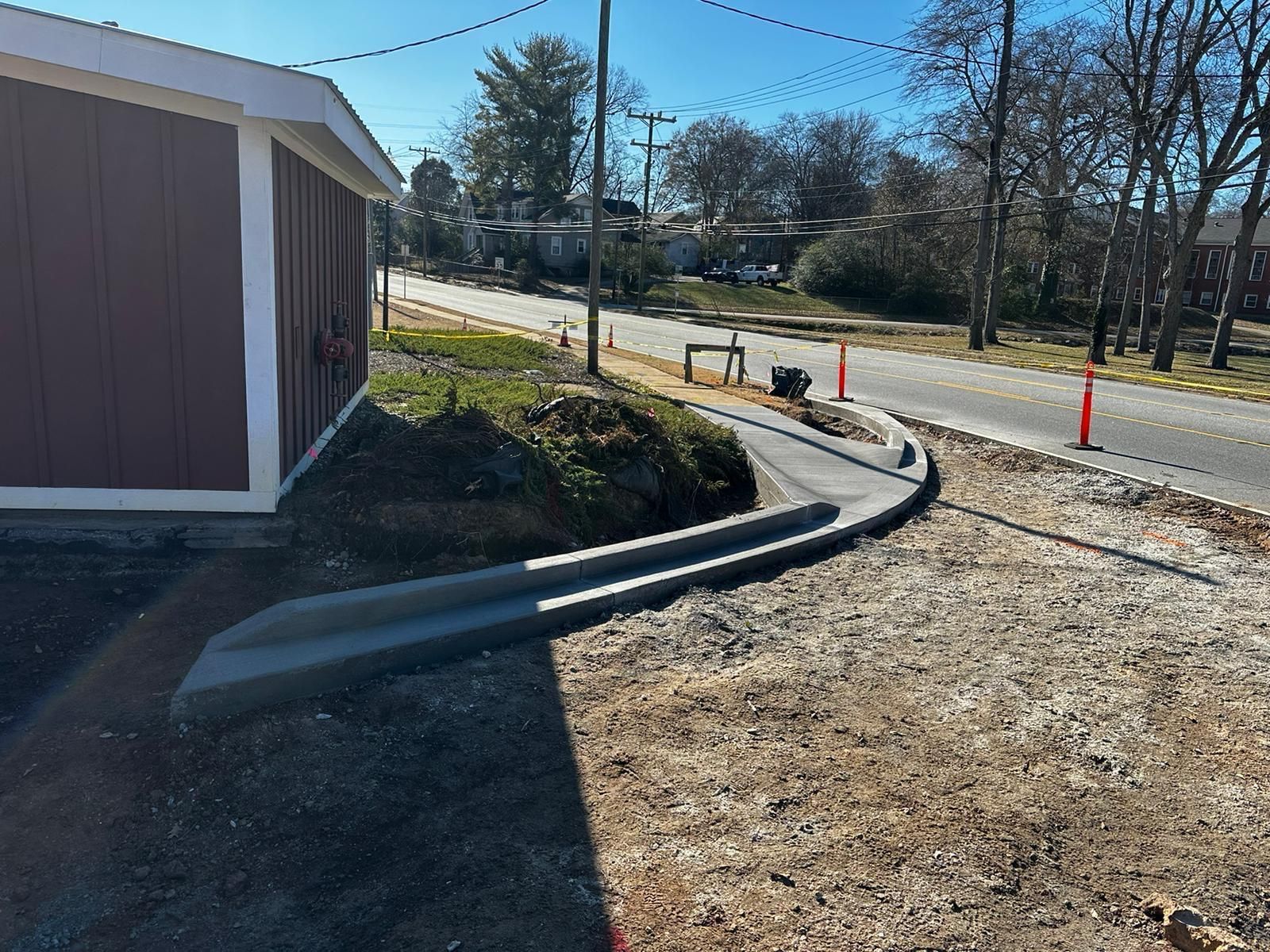 A concrete curb is being installed on the side of a road.