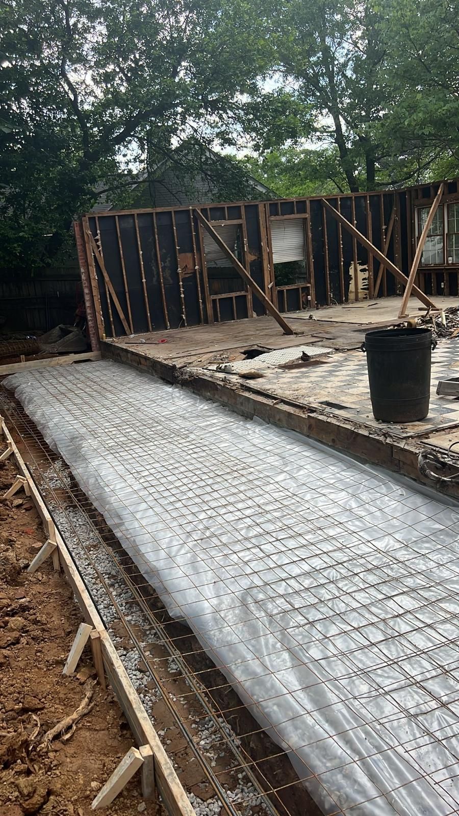 A concrete driveway is being built in a backyard.
