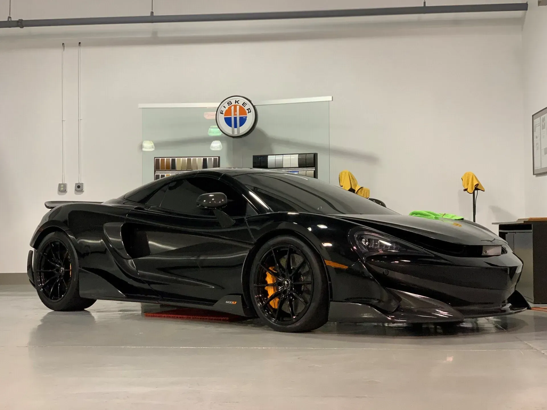 A black sports car is parked in a garage.
