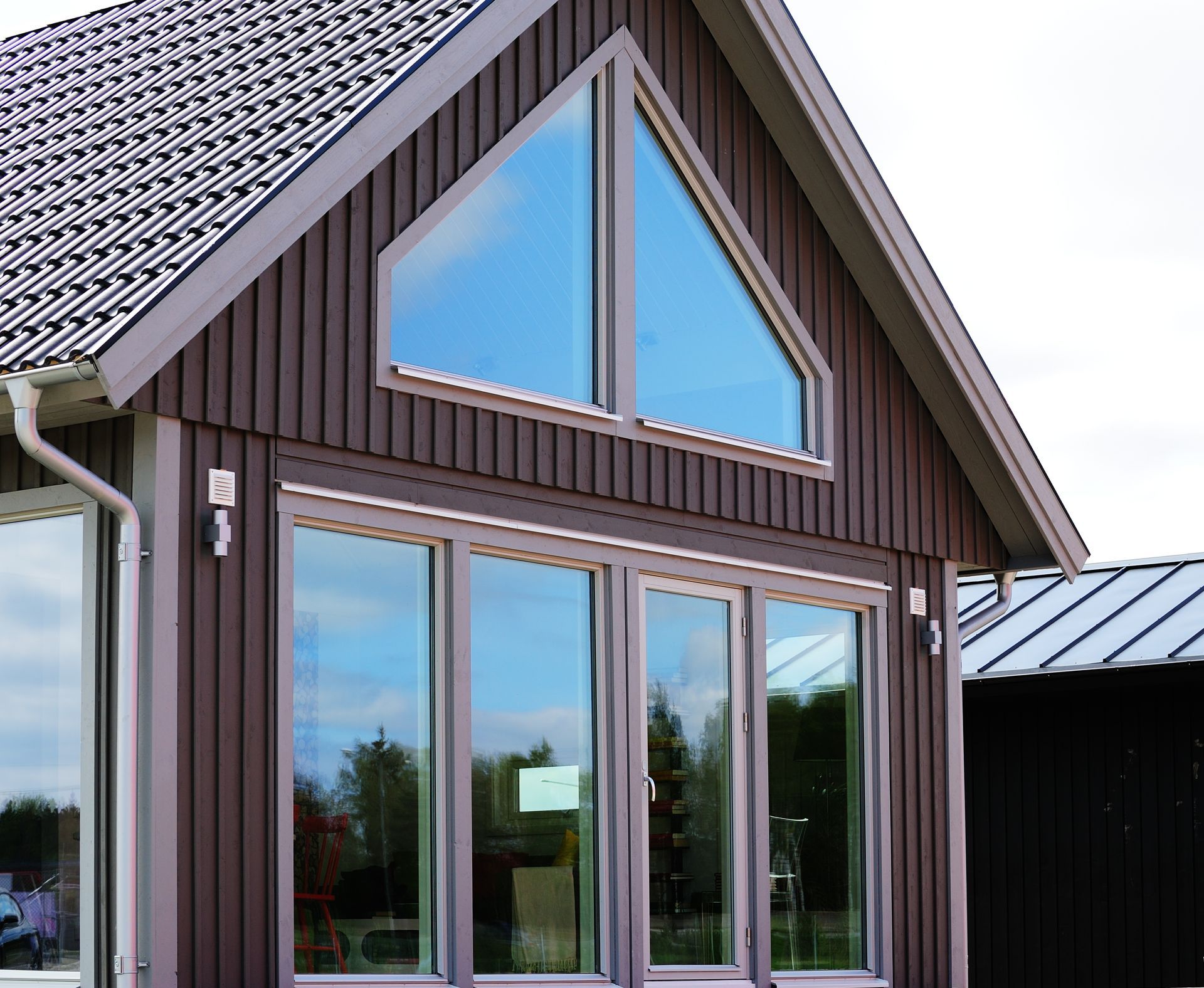 A brown house with a roof and a lot of windows