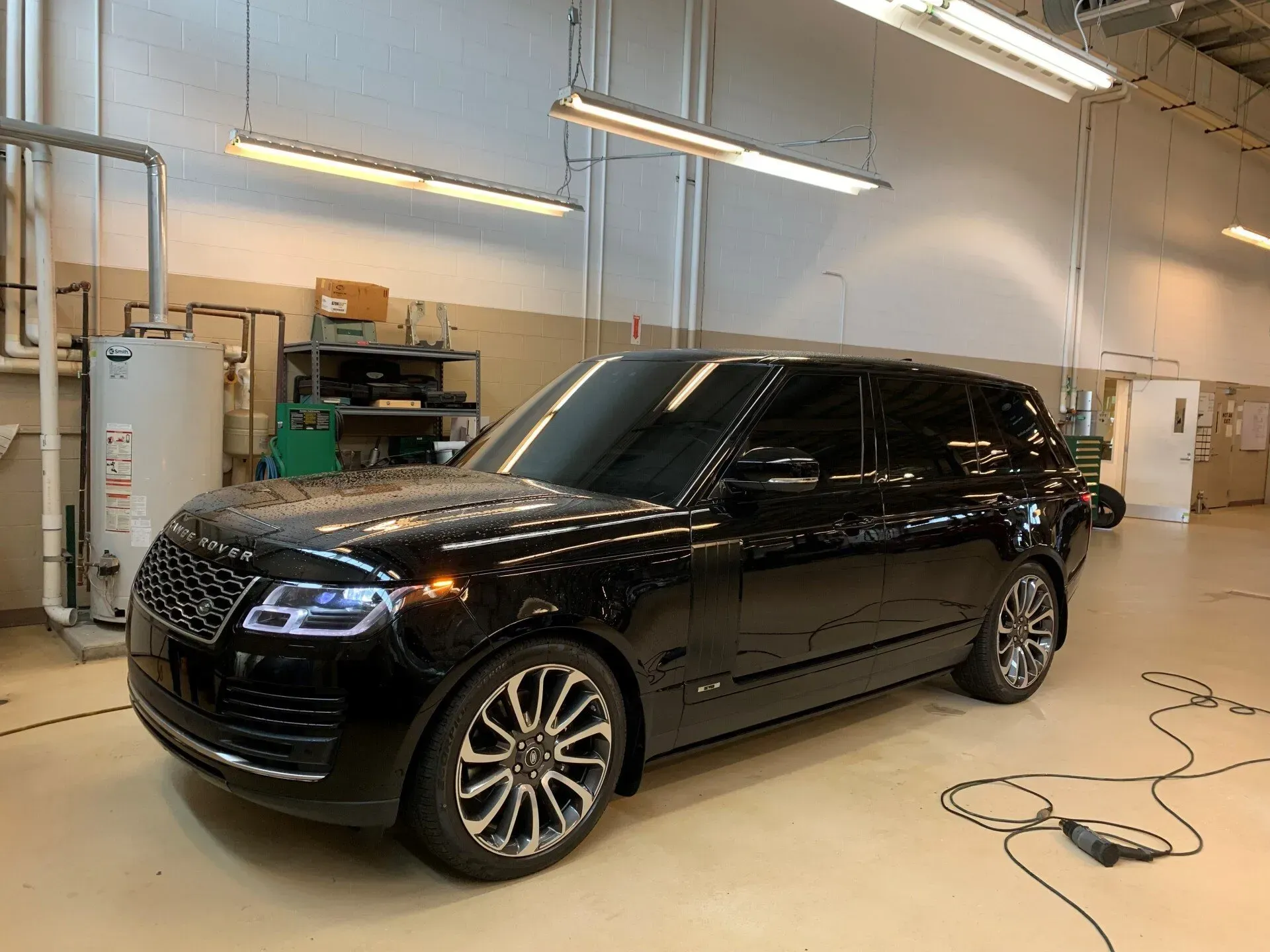 A black range rover is parked in a garage.