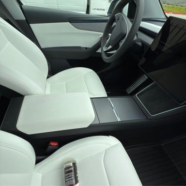 White interior of a car, including seats, dashboard, steering wheel, and center console.