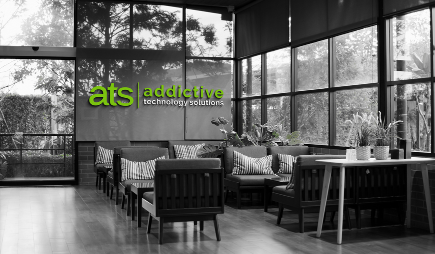 Interior of ATS Addiction Treatment Services office with seating and large windows.