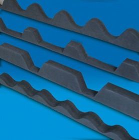 Primo piano di quattro strisce di schiuma ondulata grigia su sfondo blu.