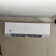 White CH brand air conditioner mounted on a beige wall.