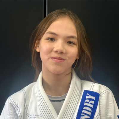 A young girl wearing a white and blue karate uniform