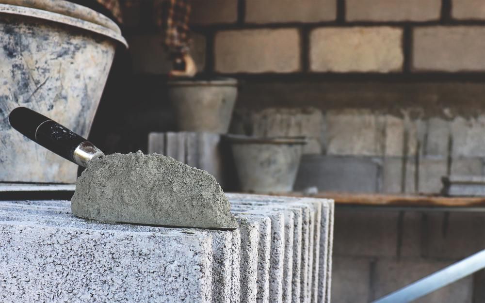 A Trowel Is Sitting On Top Of A Brick Block — Skilled Transport Training And Assessment in Woongarrah, NSW